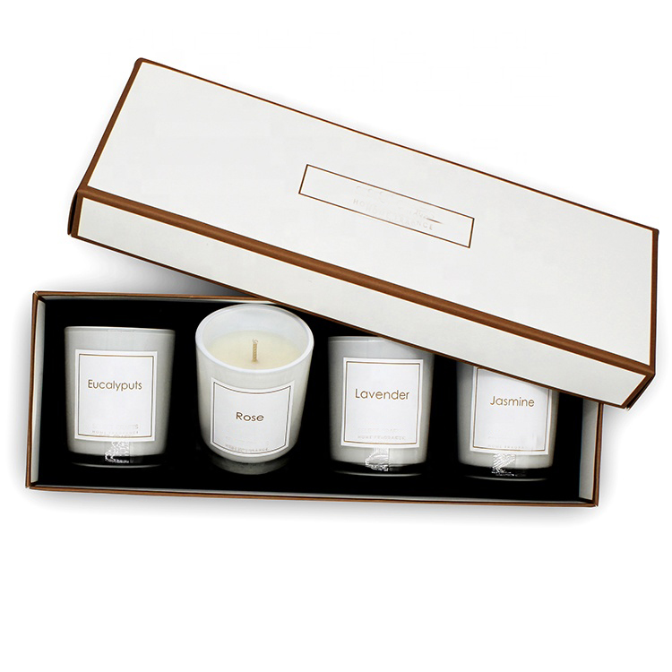 Four scented candle jars packed in a custom gift box insert
